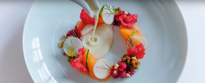 Ein Kranz aus Gemüse und Blüten, Sauce wird angegossen