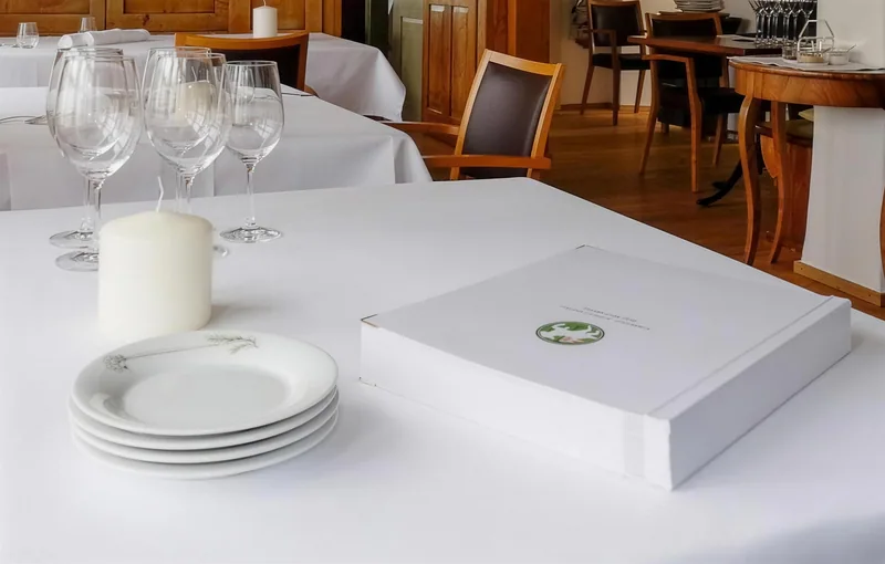 Ein weiss gedeckter Tisch mit Gläsern und Tellern in der Stube