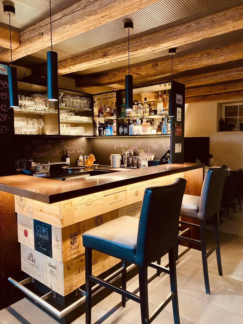 Die Bar mit Hockern und beleuchtetem Regal