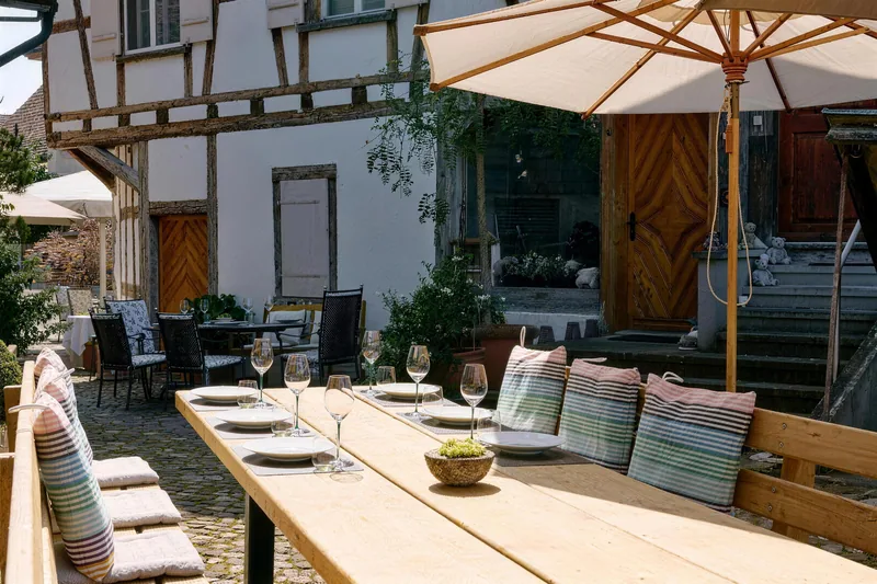 Die lange gedeckte Tafel im Hinterhof unter den Sonnenschirmen