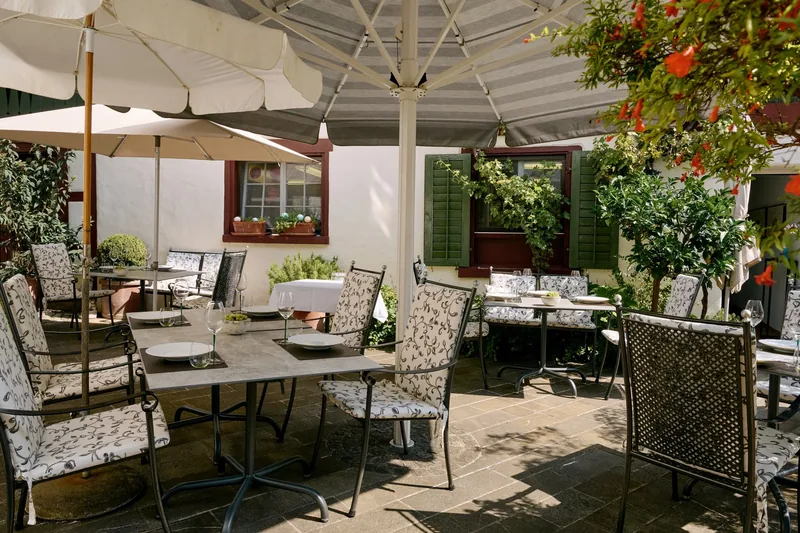 Die Terrasse mit gedeckten Tischen unter Sonnenschirmen