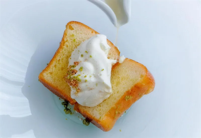 Ein getoastetes Brioche mit Crème, Sauce wird angegossen