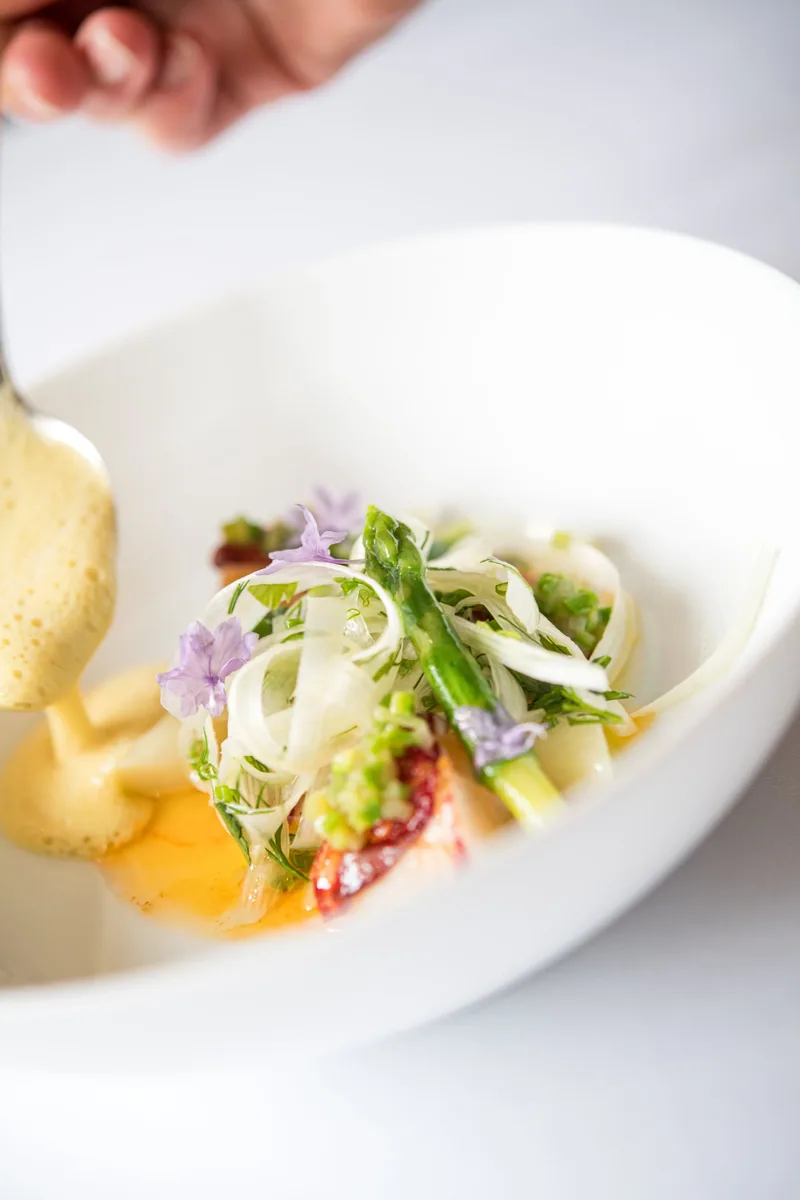 Scampi mit Thai-Curry-Nage, die Sauce wird angegossen