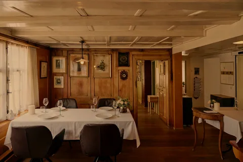 Die Gaststube mit Holztäfer und gedeckten Tischen am Abend