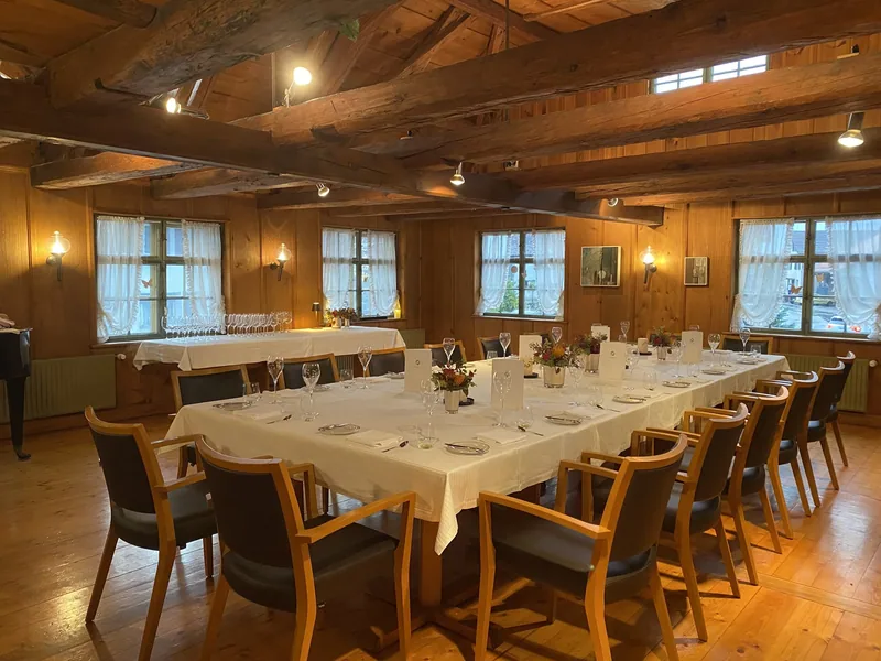 Eine lange gedeckte Tafel in einem Saal mit Holzdecke
