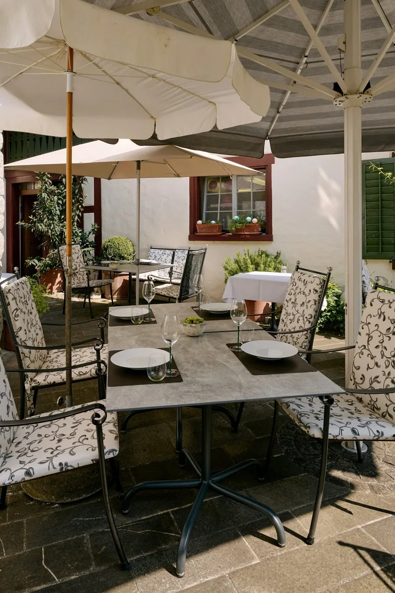Tische auf der Terrasse unter den Sonnenschirmen