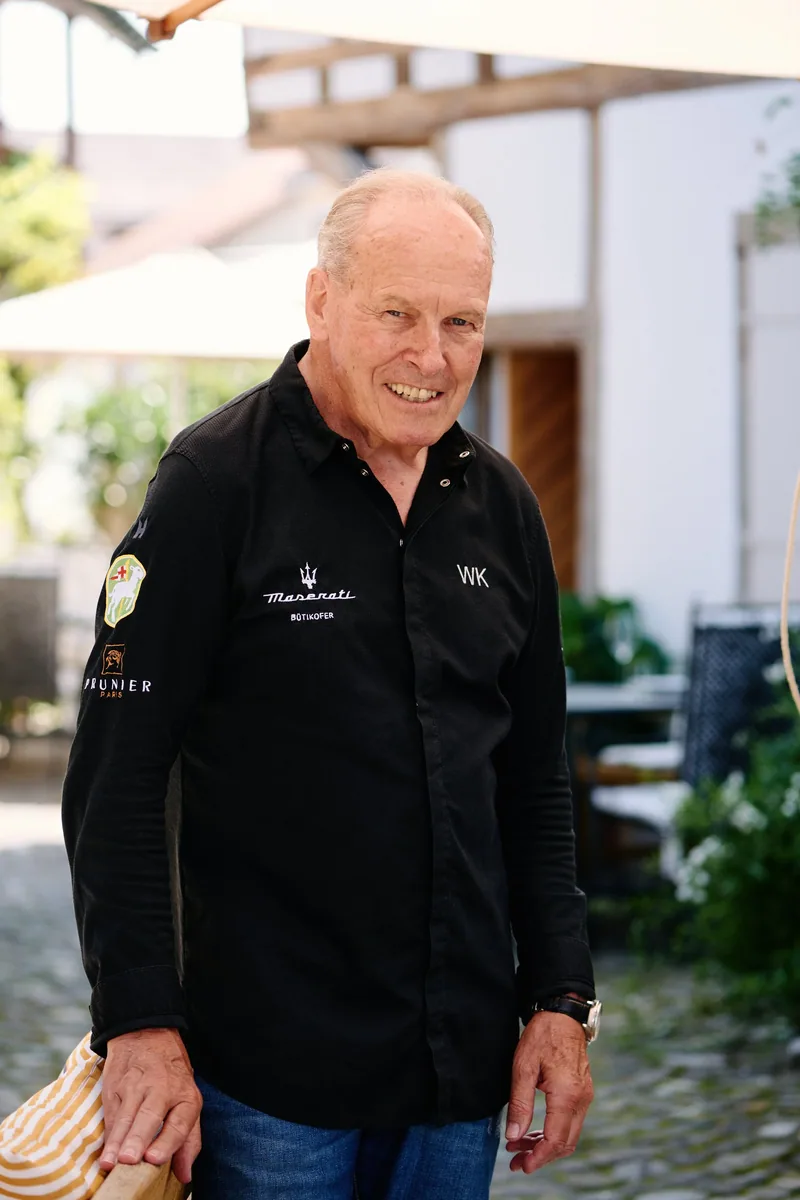 Wolfgang Kuchler in der Jacke mit seinen Initialen vor dem Haus